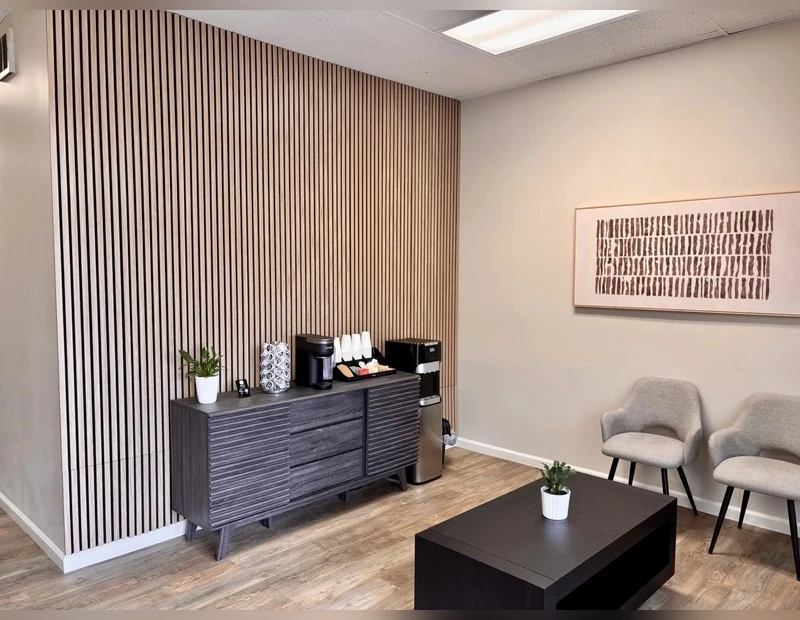 Patient waiting area with seating and refreshment station at True Chiropractic Bellevue